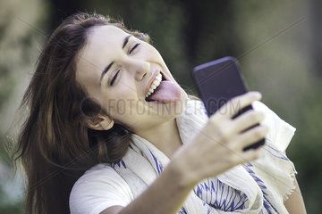 Woman taking selfie with tongue sticking out