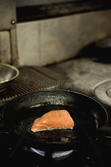 Salmon steak frying in pan