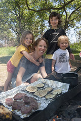 Mother and children grilling together at campsite