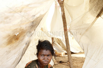Vakaneri  Sri Lanka  eine Frau sitzt in den Ueberresten eines Zelt