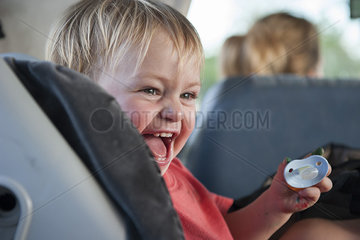 Toddler boy laughing in car