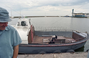 Fischer auf seinem Boot im Hafen von Nidden  Litauen