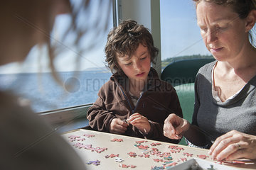 Family putting together jigsaw puzzle together