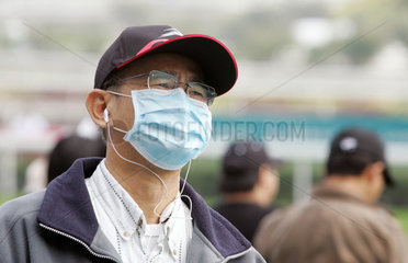 Hongkong  China  Mann mit Basecap und Mundschutz