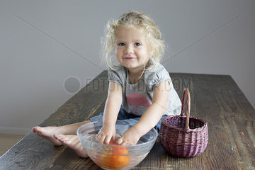 Girl rinsing vegetables in bowl