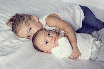Little girl cuddling with baby brother