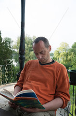 Gallin-Kuppentin  Deutschland  ein Mann sitzt auf einer Terrasse und liest ein Buch
