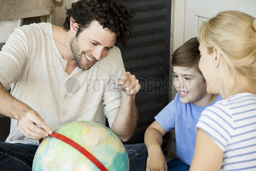 Family with one child looking at world globe together
