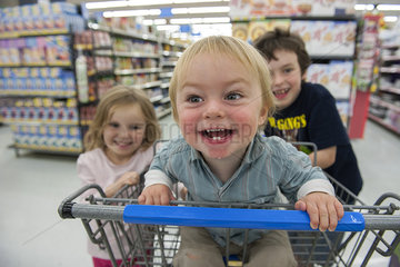 Children having fun in shopping cart