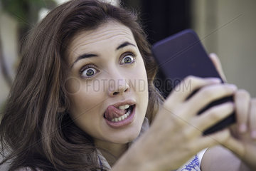 Woman making faces while taking selfie