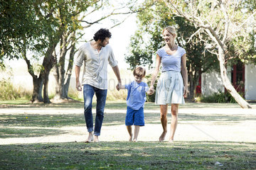 Family with one child taking walk outdoors together