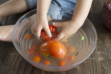 Child washing tomatoes