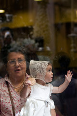 Sevilla  Spanien  Grossmutter schaut mit ihrer Enkelin der Fronleichnamsprozession zu