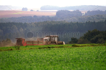 Landwirt faehrt mit seinem Trecker zwischen den Feldern