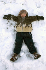 Tirol  ein Junge liegt im Schnee