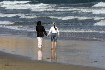 Pajara  zwei Frauen laufen Hand in Hand am Strand entlang