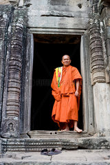 Angkor  Kambodscha  ein Moench im Eingang des Bayon