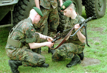 Zwei Soldaten bauen ein Maschinengewehr zusammen.
