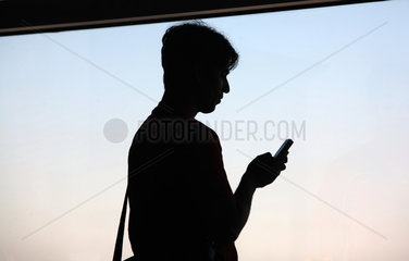 Frankfurt am Main  Deutschland  Silhouette eines Mannes mit Mobiltelefon in der Hand