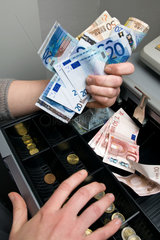 Berlin  Deutschland  Bargeld wird aus der Registrierkasse entnommen