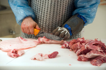 Berlin  Deutschland  ein Fleischer beim Schneiden von frischem Fleisch