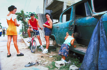 Kubaner stehen an einem alten Auto auf der Strasse