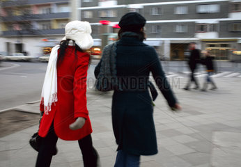 Berlin  zwei Frauen gehen schnell eine Strasse entlang