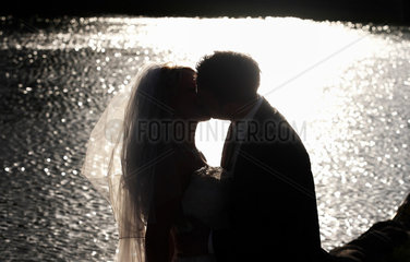 Berlin  Deutschland  Silhouette eines Brautpaars an einem See