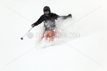 Belalp  Schweiz  ein Mann faehrt Ski im Tiefschnee