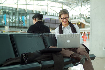 Hamburg  Deutschland  Geschaeftsfrau mit ihrem Macbook Pro im Flughafen