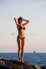 Bogliasco  Italien  Frau im Bikini sonnt sich in der Abendsonne am Meer