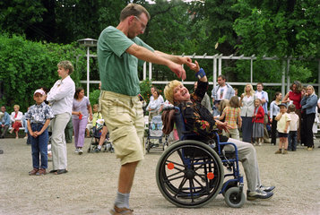 Mann tanzt mit Rollstuhlfahrerin in Poznan  Polen