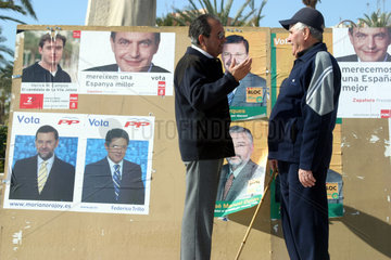 Zwei Herren vor Wahlplakaten in Spanien