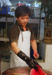 Hongkong  China  Mann filetiert einen Fisch