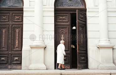 Aeltere Frau betritt eine Kirche  Lodz  Polen