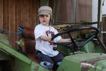 Birkach  Deutschland  Kleinkind sitzt auf einem Traktor