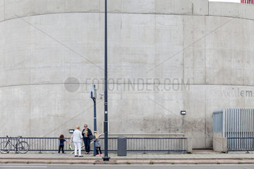 Rotterdam  Niederlande  Fahrgaeste warten an einer Bushaltestelle vor einer Betonwand