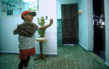 Ein kubanischer Junge spielt Baseball in der Wohnung