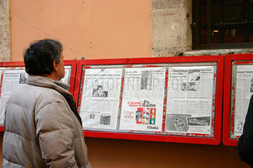 Ein Mann beim lesen der l'Unita vor eine Sektion der ehemalige KPI.