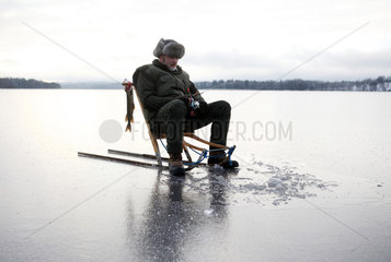 Belloe  Schweden  Mann beim Eisangeln auf dem See Stora Bellen