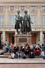 Weimar  Deutschland  eine Schuelergruppe sitzt unter dem Goethe-Schiller-Denkmal