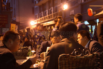 Peking  Chinesen essen im Strassenlokal