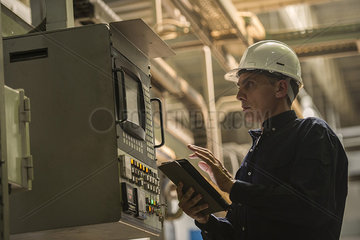 Factory worker using digital tablet in factory