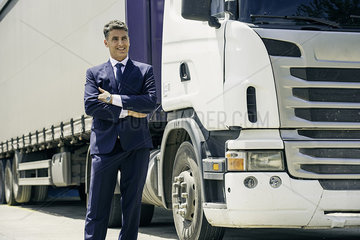 Businessman standing in front of lorry