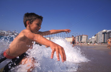 Ein Kind im Wasser am Stadtstrand von La Coruna