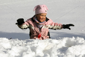 Tirol  ein Maedchen tobt im Schnee