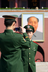 Peking  Soldat laesst sich vor Mao-Portraet fotografieren
