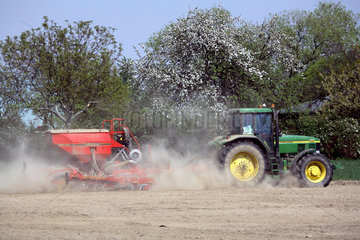 Traktor auf trockenem Feld wirbelt Staub auf