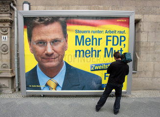 Berlin  Kameramann filmt ein Wahlplakat fuer die FDP