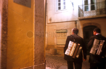 Musiker laufen durch das abendliche Lissabon